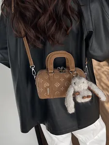Brown frosted leather baguette bag with floral embossing and a cute rabbit pendant