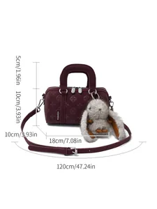 Elegant wine red cylinder bag with floral embossing and fuzzy bunny charm accessory