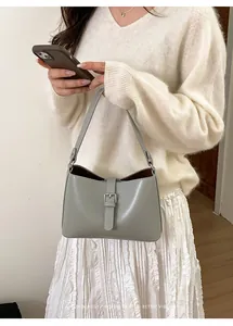 Détail d'un sac à main en cuir gris avec boucle argentée et coutures élégantes