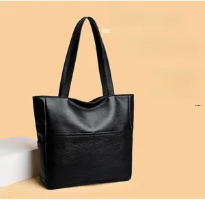 Close-up of black PU leather tote bag showing soft texture and front pocket detail
