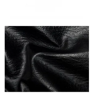 Close-up detail of soft black lychee pattern leather with high-quality refined texture
