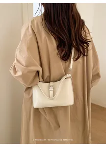 Gros plan du sac bandoulière en cuir crème minimaliste avec boucle rétro vintage