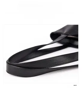 Detail of reinforced black faux leather handle with precision stitching on a tote bag