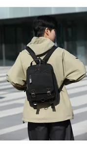 Vista posteriore di un uomo con zaino in tela nera e dettagli in pelle marrone in città