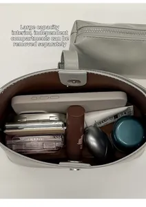 Intérieur spacieux d'un sac cabas en cuir gris clair avec pochette amovible et produits de beauté