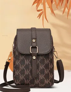 Detailed view of the dark brown monogram crossbody bag with metallic gold snap closure