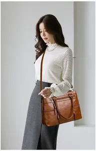 Brown leather tote bag with multi-pocket details and tassels shown on a model