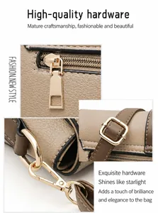 Detailed macro view of light gold hardware and textured pebble leather on a handbag