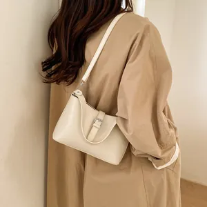 Sac à bandoulière minimaliste crème en similicuir avec boucle sur un mannequin