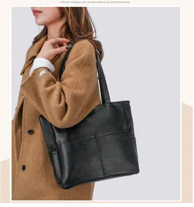Detail of minimalist black tote bag with soft leather texture and geometric stitching