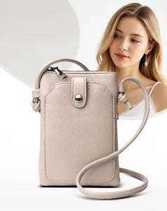 Détail du sac à téléphone beige en cuir grainé avec bouton-pression en métal et bandoulière