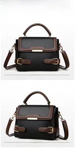Detail of black and brown leather handbag showing gold hardware and litchi texture