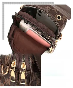 Detail view of double-layer zipper and monogram pattern on brown crossbody phone bag