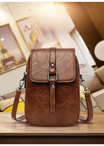 Gros plan détaillé d'un mini sac à bandoulière vintage marron sur une surface en bois