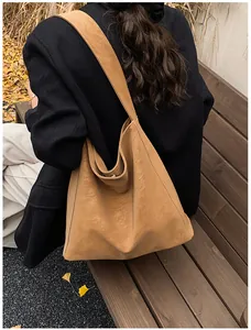 Λεπτομέρεια μεγάλης vintage καφέ τσάντας tote με φαρδύ λουρί από συνθετικό καστόρι