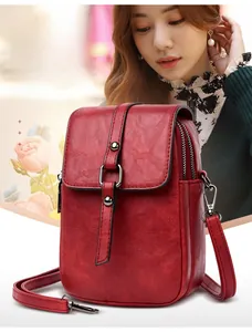 Détail du mini sac bandoulière vintage rouge en simili cuir avec boucles argentées