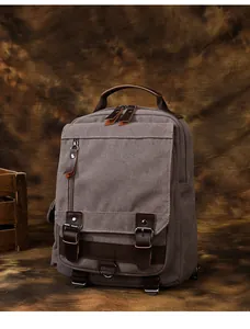 Dettaglio dello zaino in tela vintage con cinturini in pelle e struttura a tasche multiple