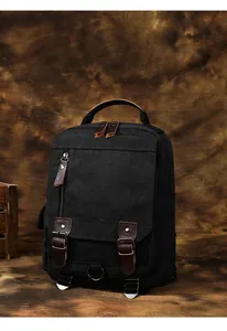 Dettaglio dello zaino in tela vintage con finiture in pelle marrone e parti metalliche