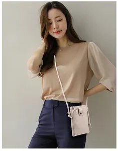Détail d'un mini sac bandoulière beige en cuir avec bandoulière nouée et fermeture éclair