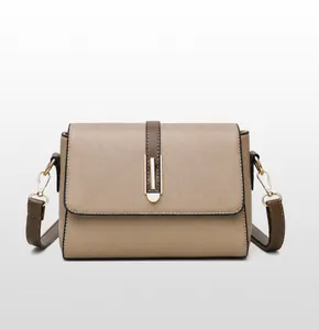 Front view detail of khaki soft leather crossbody bag with brown straps and gold buckle
