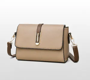 Three-quarter view of a two-tone leather shoulder bag with golden metal buckle