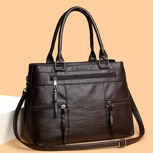 Large capacity caramel brown leather handbag with multiple zippers and shoulder strap