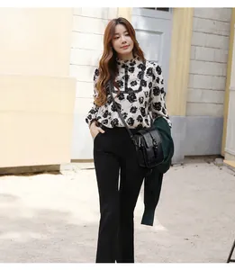 Femme élégante portant un chemisier à fleurs et un petit sac à bandoulière noir en cuir