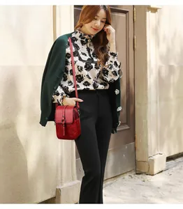 Détail d'un mini sac bandoulière rouge avec boucle métallique et bandoulière réglable
