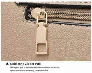 Close-up of premium golden metal zipper puller on beige lychee texture leather bag