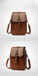 Détail du mini sac bandoulière marron montrant le cuir grainé et les boucles métalliques