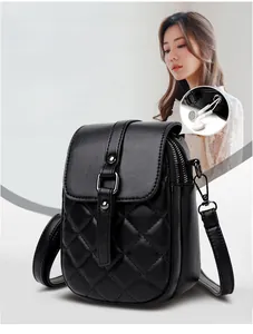 Detail of black quilted crossbody phone bag showing the side headphone jack feature