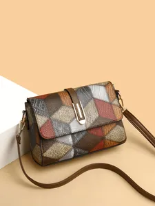 Detail showing multi-textured leather patchwork and gold clasp on women's crossbody bag