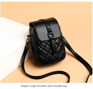Close-up of black quilted faux leather crossbody bag with metallic clasp detail