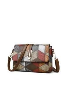 Close-up of patchwork leather crossbody bag with rhombic patterns and metallic buckle