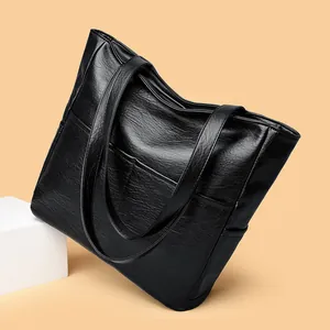 Black soft faux leather tote bag with large capacity for daily commute on light background