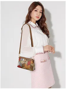 Dettaglio della borsa a tracolla bohemian con motivo patchwork e logo floreale in metallo