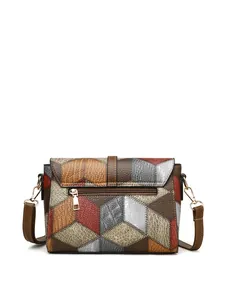 Detail of vintage patchwork leather shoulder bag with zipper pocket and metal hardware