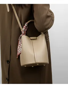 Detail of khaki bucket bag featuring lychee grain leather and decorative handle scarf