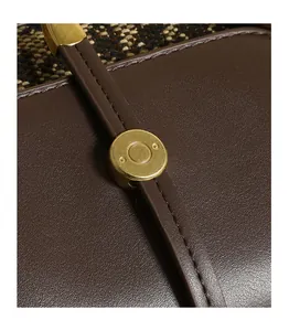Detail of premium brown lychee grain leather stitching and retro gold metal buckle