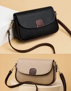 Detail van crossbodytassen in korrelig leer met gouden sluiting en nette stiksels