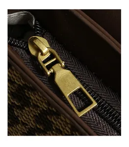 Detailed close-up of golden matte zipper and premium stitching on canvas shoulder bag