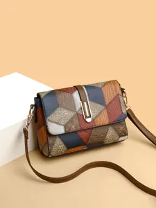 Detailed view of the patchwork faux leather shoulder bag with gold hardware and texture