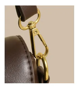 Detail of high-quality golden metal lobster clasp and brown lychee grain leather strap