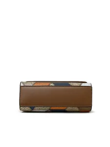 Detail of the multi-colored patchwork handbag base with brown leather and precise stitching