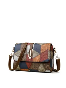 Detail of color-block leather shoulder bag with snake skin texture and gold metal buckle