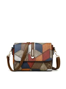 Detail of color-block geometric pattern and metallic lock on a soft leather handbag