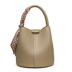 Minimalist khaki bucket bag with lychee grain leather and silk scarf handle detail