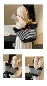 Λεπτομέρεια της ασπρόμαυρης ριγέ υφαντής τσάντας με καφέ δερμάτινους ιμάντες ώμου