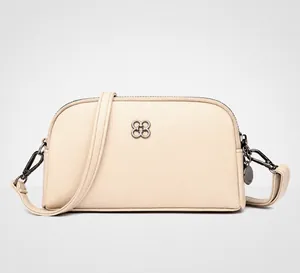 Dettaglio borsa a tracolla mini color mandorla con logo a quadrifoglio e doppia zip