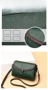 Detail of dark green crossbody bag featuring lychee grain texture and white contrast stitching